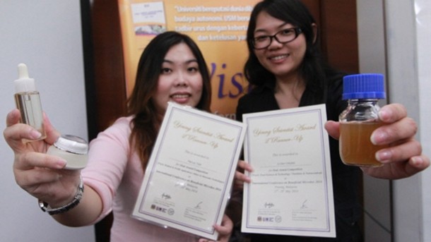 The two young researchers show off their awards